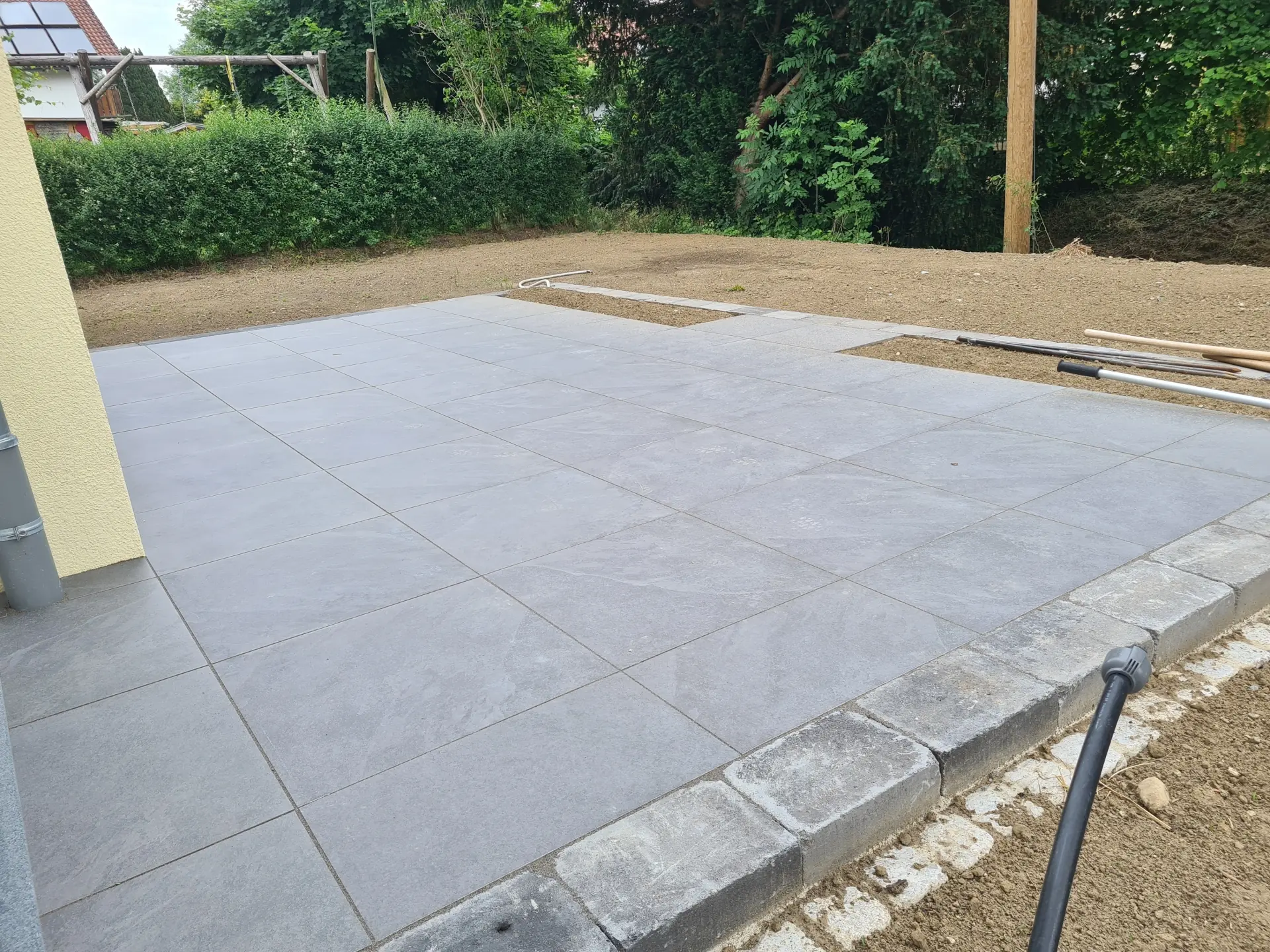 Gartenneuanlage mit moderner Terrasse aus grauen Bodenplatten