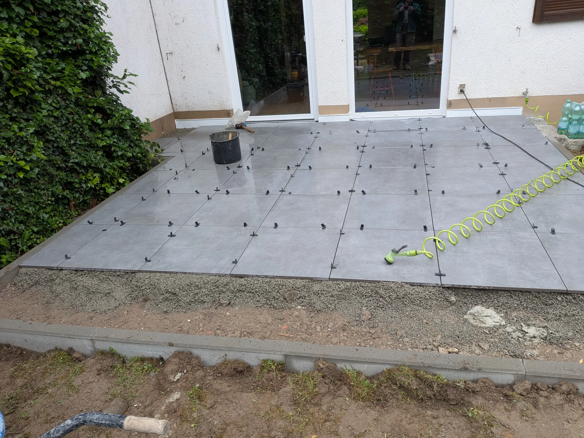 Terrasse im Bau mit Bodenplatten und Abstandshaltern im Rahmen einer Gartensanierung