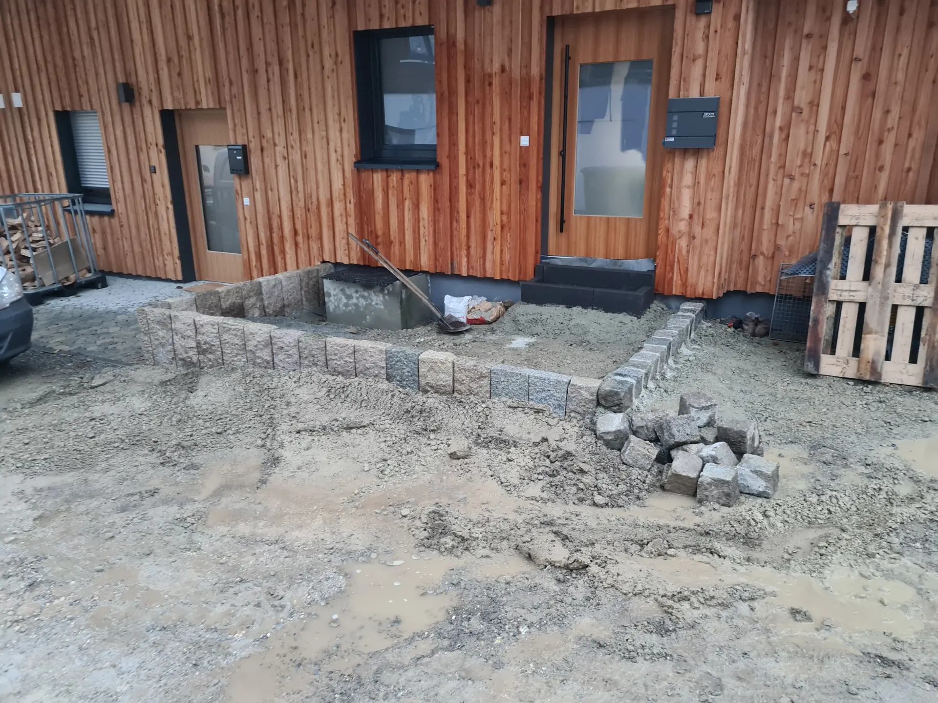 Nachher-Bild eines fertiggestellten Eingangsbereichs mit Naturstein nach der Gartensanierung