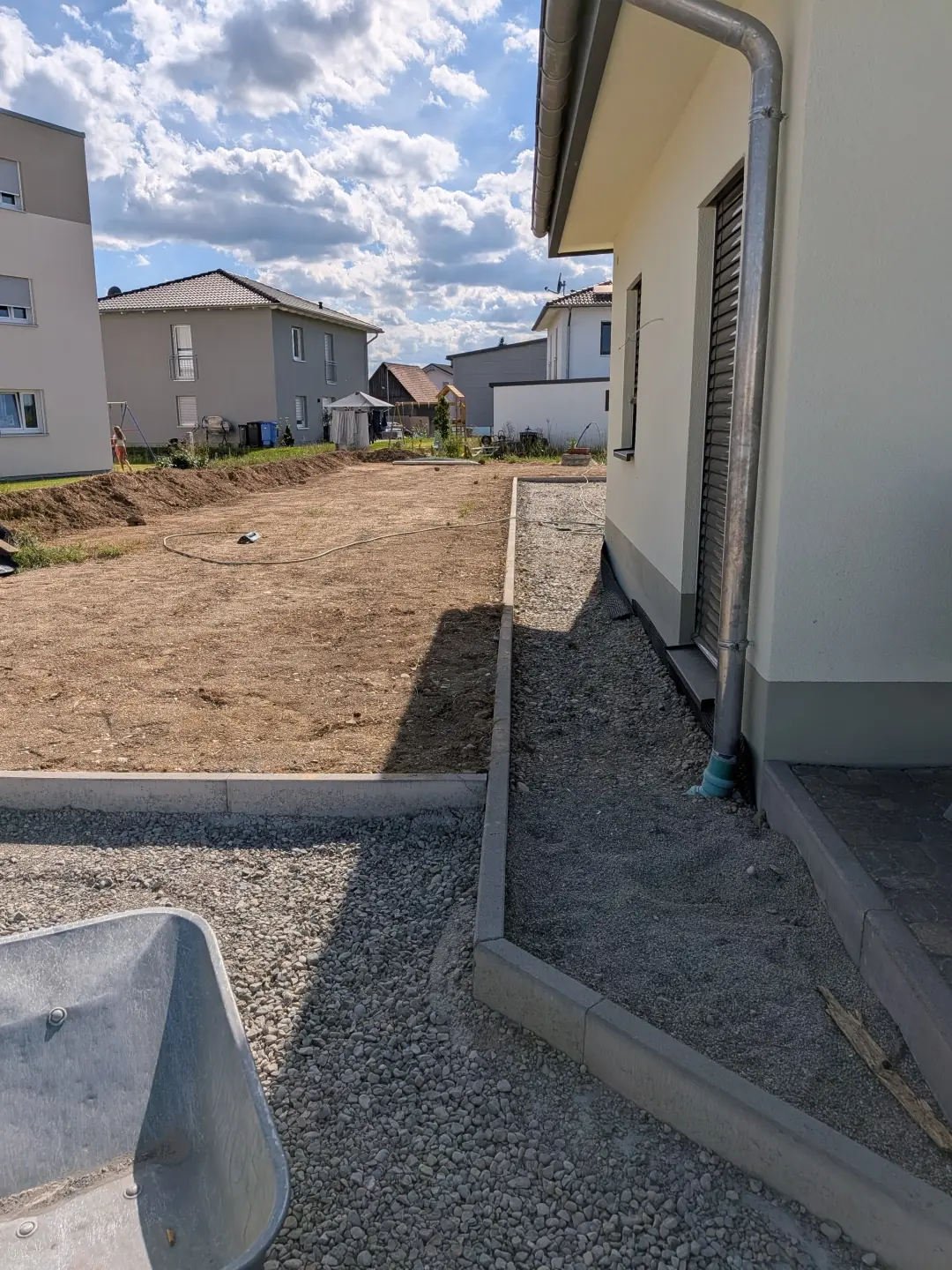 Erdarbeiten rund ums Haus Erdarbeiten zur Trennung von Gartenfläche und Hausumrandung als Vorbereitung für Außenanlagen
